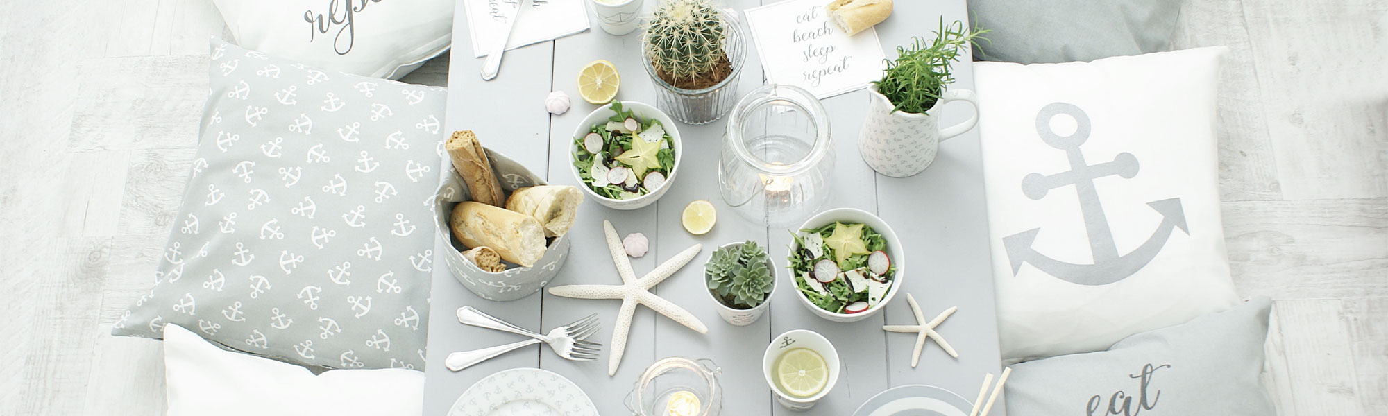 Anchor themed cushions and dinner service on dining table